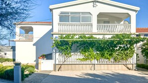Ein zweistöckiges Haus mit Balkon und überdachter Veranda.