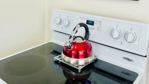 Uma cozinha com fogão, chaleira e um mapa emoldurado na parede.
