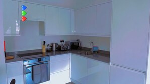 A modern kitchen with white cabinets, a built-in oven, a microwave, a toaster, and a sink. - The Ridgmont-st Albans-high Street- Near Luton Airport -train Station-balcony (St Albans)