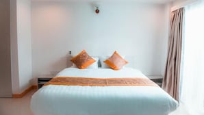 A modern hotel room with a large bed, a ceiling light fixture, and a window with curtains. - Morus Bliss - Divers' Preferred Hotel (Hithadhoo)