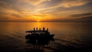 A boat with people on a calm body of water during sunset. - Morus Bliss - Divers' Preferred Hotel (Hithadhoo)