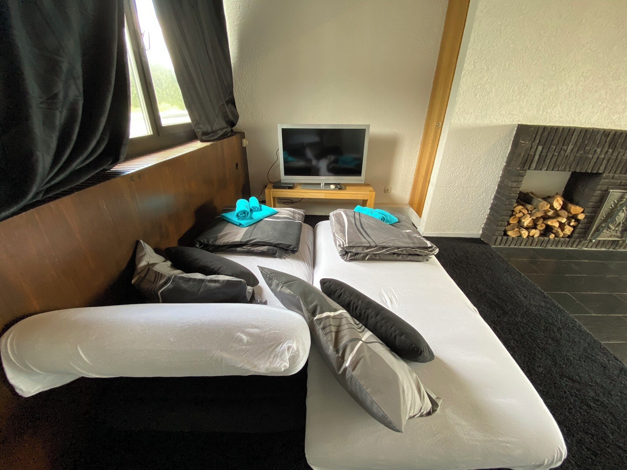 Une chambre moderne équipée d’un lit, d’une télévision et d’une cheminée.