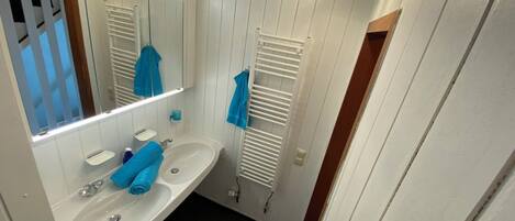 A bathroom with a white sink, mirror, and towel rack.