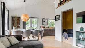 A modern living room with a sofa, dining area, and kitchen. - 3 bedroom pet friendly home in ørsted (Ørsted)