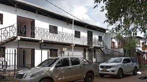 Ein Gebäude mit weißer Fassade, zahlreichen Fenstern und einem Balkon mit Metallgeländer.