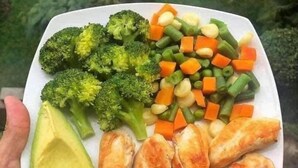 Ein Teller mit Brokkoli, Karotten, Erbsen, Hähnchen und Avocado.