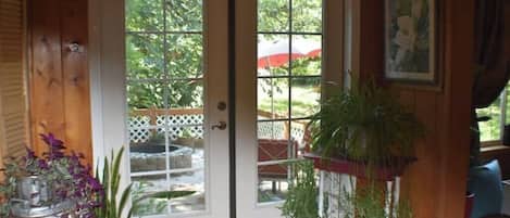 A wooden door with glass panels, a potted plant, and a framed picture on the wall.
