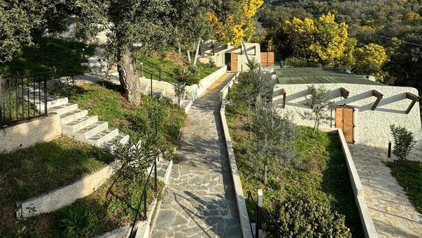 A stone pathway leading to a building with a white exterior and a wooden door. - Apartement Avec Terrasse A 10 MN DES Plages A Pieds (LE LAVANDOU)