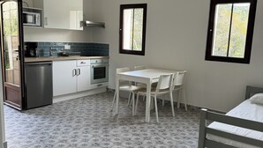A compact kitchen with a dining area, a bed, and a window. - Apartement Avec Terrasse A 10 MN DES Plages A Pieds (LE LAVANDOU)