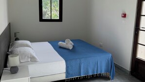 A bedroom with a bed, a bedside table, a lamp, a window, and a door. - Apartement Avec Terrasse A 10 MN DES Plages A Pieds (LE LAVANDOU)