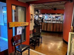 A restaurant interior with a bar area, chairs, and a sign indicating 'Fireplace'.