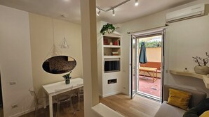A modern living room with a dining area, a built-in TV, and a sliding glass door leading to an outdoor patio. - 2 bedroom apartment in rome (Roma)