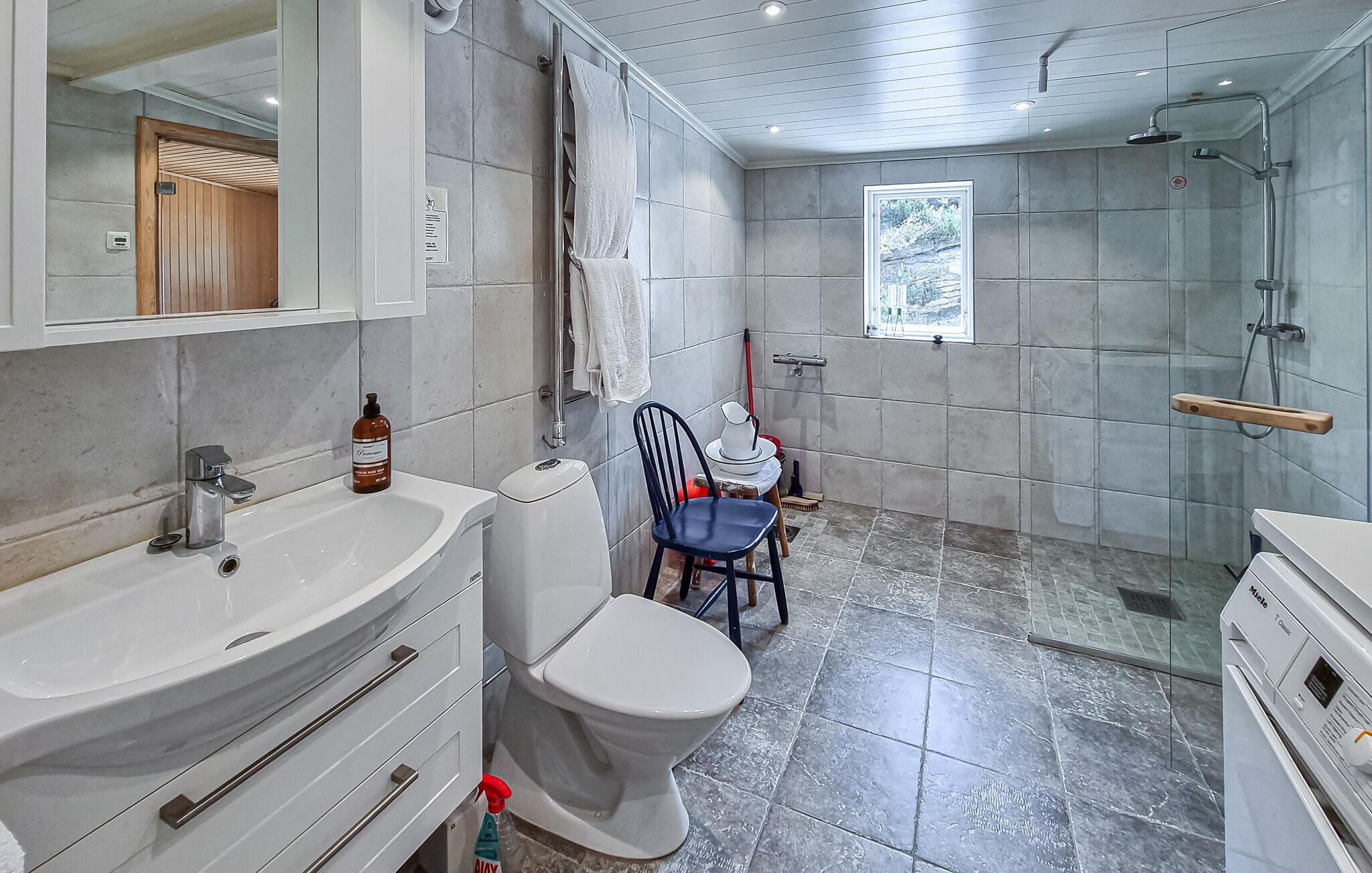 Een badkamer met een witte wastafel, toilet en douche.
