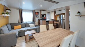 Un espace de vie compact comprenant un canapé, une table à manger et une kitchenette.