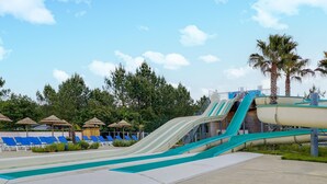 Un parc aquatique doté de nombreux toboggans et de chaises longues.
