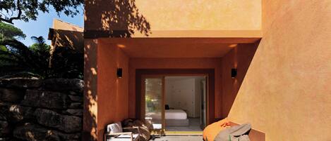A modern bedroom with a bed, a wooden floor, and a stone wall.