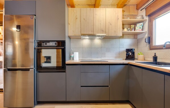 Una cocina moderna con electrodomésticos de acero inoxidable, armarios de madera y horno empotrado.