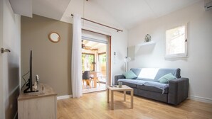 Ein Wohnzimmer mit einem grauen Sofa, einem Holztisch und einem Beistelltisch mit einer Lampe.
