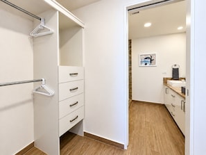 Ein modernes Badezimmer mit einem weißen Waschbecken, einem Spiegel und Holzboden.