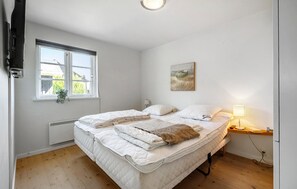 A bedroom with a bed, a window, a wall-mounted lamp, and a painting. - Awesome home in Nysted with house sea view (Nysted)