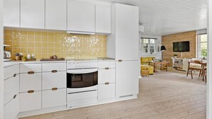 A modern kitchen with white cabinets, a yellow backsplash, and a built-in oven. - 3 bedroom awesome home in Brenderup Fyn (Brenderup Fyn)