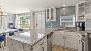 A modern kitchen with white cabinets, a granite countertop, and stainless steel appliances. - !Newly Upgraded! Hot Tub-Game Room-Dock-Fire Pits (Millersport)