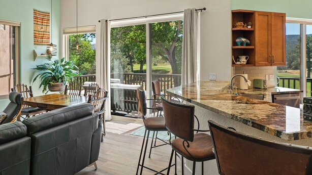 A spacious kitchen with a large island, bar stools, and a dining area with a couch and chairs. - Red Rock Views! Pool~Pickleball~Hike~Golf, Deck Overlooks the 9th Green! Sedona (Sedona)
