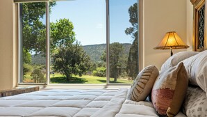 A bed with a view of a green landscape through large windows. - Red Rock Views! Pool~Pickleball~Hike~Golf, Deck Overlooks the 9th Green! Sedona (Sedona)