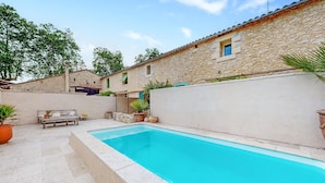 A swimming pool area with stone walls, a bench, and potted plants. - Nice home in Port-Sainte-Foy-Pontch (Port-Sainte-Foy-Pontch)