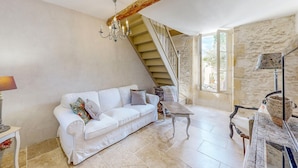 A spacious living room with a white sofa, a chandelier, a staircase, and a view of the outdoors. - Nice home in Port-Sainte-Foy-Pontch (Port-Sainte-Foy-Pontch)