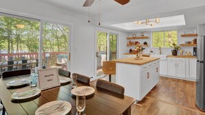 Eine moderne Küche mit weißen Schränken, einer Holzeinsel und einem Deckenventilator.