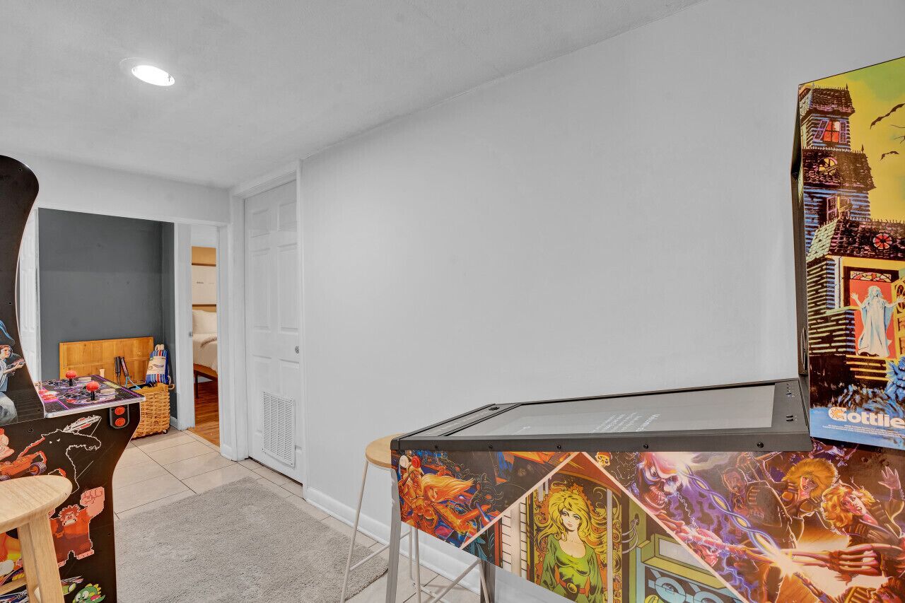 A room with a gaming table, a poster, and a door leading to another room.