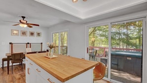 Eine moderne Küche mit einer Holzausziehtafel, weißen Schränken und einem Deckenventilator.