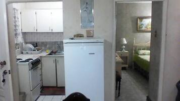 A compact kitchen with basic appliances and a dining area.