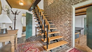 Eine Holztreppe mit einer Ziegelwand, einem Holzboden und einem gemusterten Teppich.