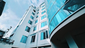 A modern building with a curved glass facade and multiple windows. - Departamento Centrico en Loja (Loja)