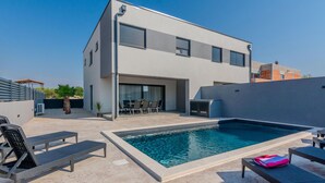 A modern two-story house with a swimming pool, outdoor seating, and a covered patio area. - Luxurious home in Vrsi (Vrsi)