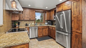 A modern kitchen with wooden cabinets, stainless steel appliances, and a granite countertop. - Mountain modern-At the base (Steamboat Springs)