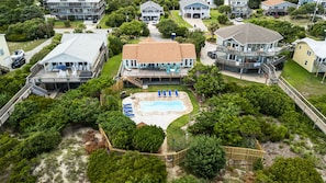 A residential area with a swimming pool surrounded by lush greenery and multiple houses.