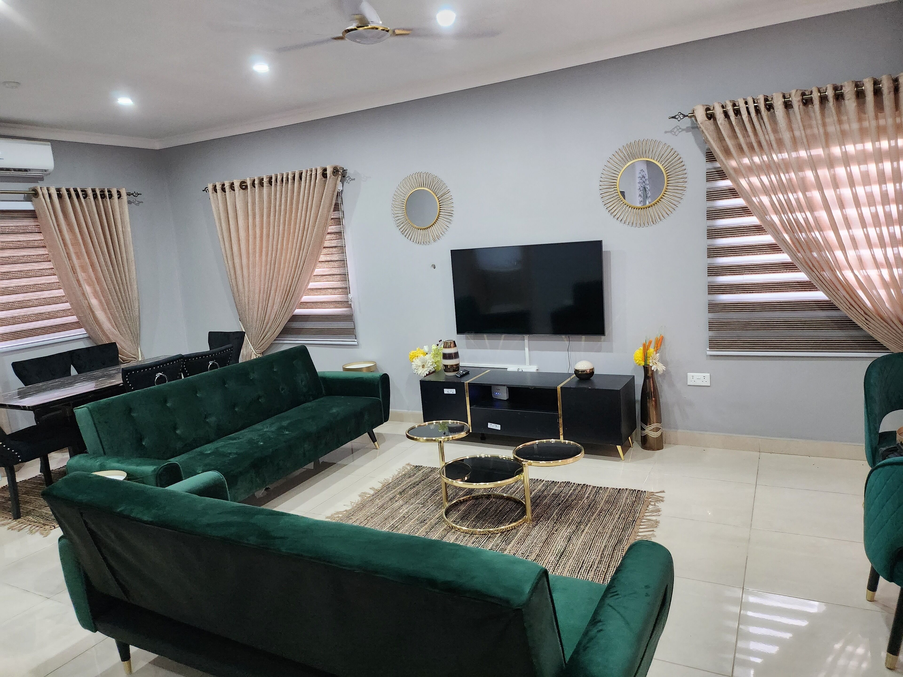 Un salón con un sofá verde, un televisor de pantalla plana y una mesa de centro.