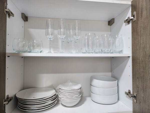 A white cabinet with shelves holding clear glassware and stacked white plates. - Spacious Luxury 3Bed Hse in Tema Netflix (Tema)