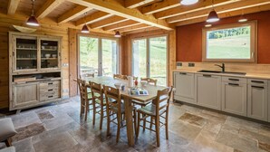 A wooden interior with a dining table, chairs, cabinets, and a window. - Apartment 'Le Chalet De La Source' with Mountain View, Private Terrace and Wi-Fi (Montagnole)