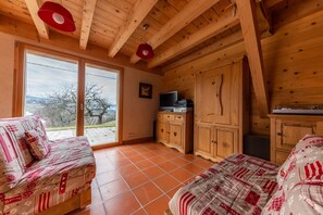 Un intérieur en bois avec un canapé, un meuble et un téléviseur.