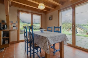Un espace repas comprenant une table et des chaises, une machine à café et une vue sur l’extérieur.