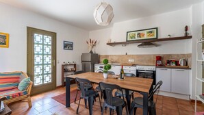 Une cuisine équipée d’une table à manger, de chaises, d’une cuisinière, d’un évier et d’un réfrigérateur.