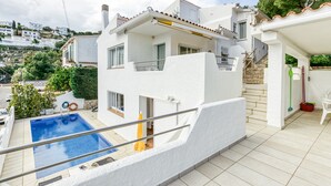 A white building with a swimming pool, a covered patio, and a view of the surrounding area. - Holiday Home "Punta Montgó" with Sea Views, Private Pool and Wi-Fi (l'Escala)