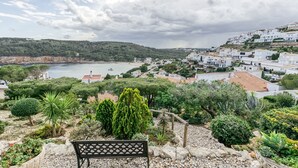 A coastal town with a bench overlooking a garden and sea view. - Holiday Home "Punta Montgó" with Sea Views, Private Pool and Wi-Fi (l'Escala)