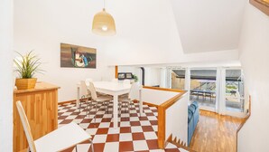 Een modern interieur met een geruite vloer, witte meubels, een hanglamp en uitzicht door grote ramen.