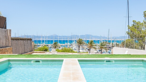 Une piscine avec vue sur un port de plaisance et des bateaux.
