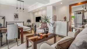 Una sala de estar moderna con un sofá, una mesa de comedor y un televisor.